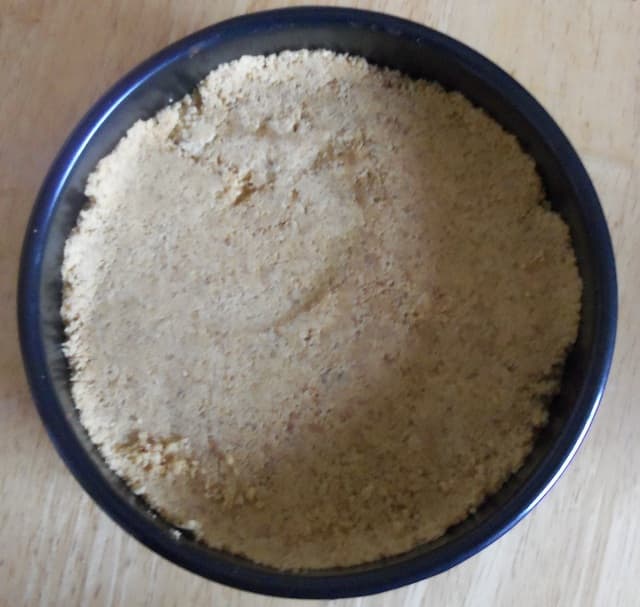 When you have added the butter to your biscuit crumbs, press into your cake pan to create a firm crust.