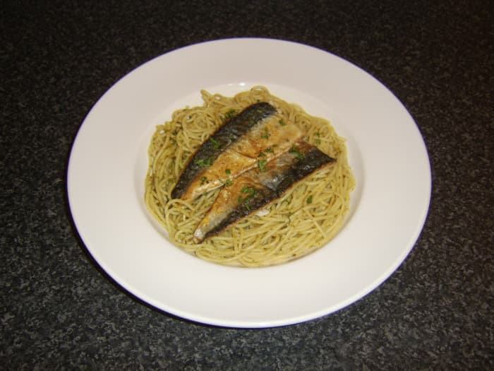 Spaghetti is cooked as normal before being stirred with green pesto sauce and topped with quickly fried mackerel fillets