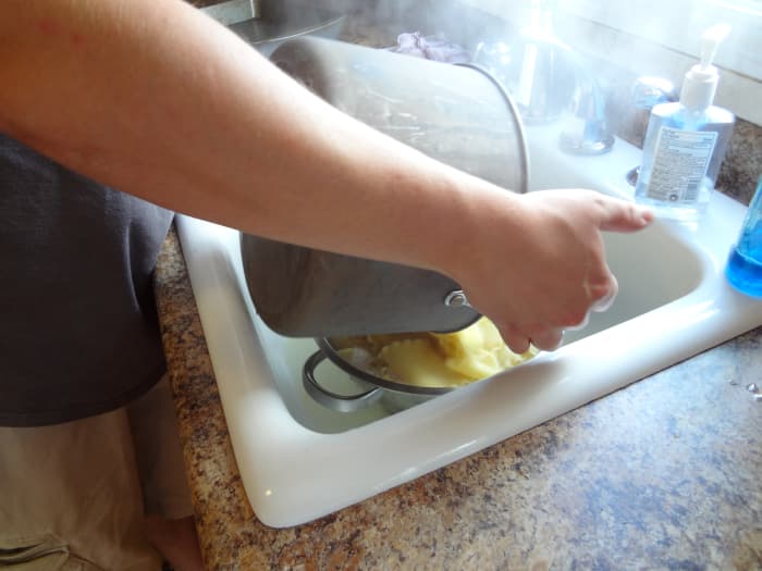 Drain the water, then run cold water over the noodles in the strainer to cool them off enough that you will be able to handle them later.
