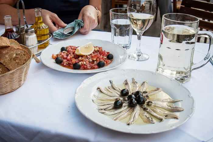 Anchovies and olives (in the foreground) as part of a meal