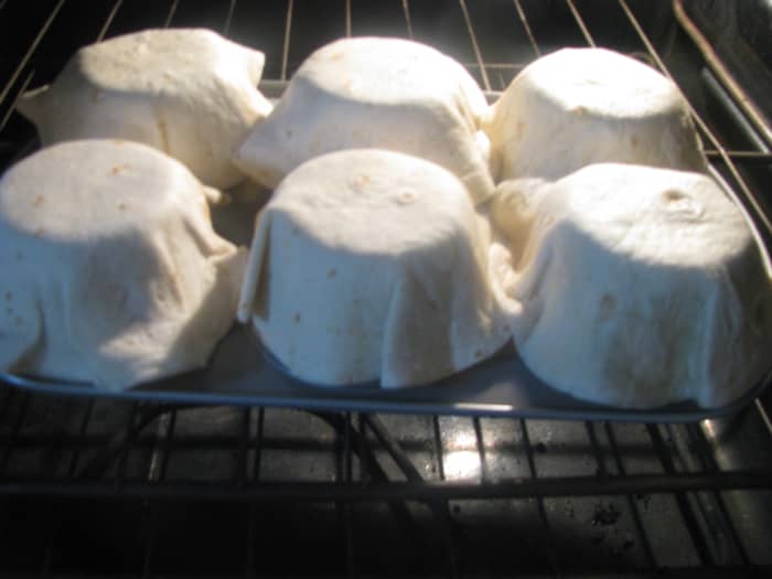 Step Five: Bake the bowls on the muffin tin for about 8 minutes. Check often so they don't burn. Once they are lightly browned and crisp remove muffin tin from oven. Let taco shell bowls cool before serving.