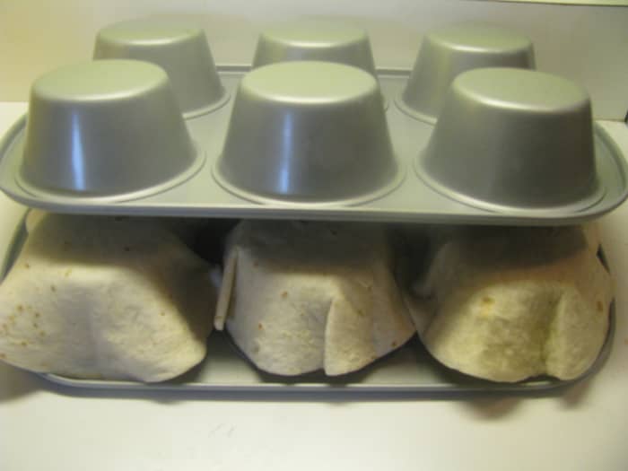 Step Three: After you have all six tortillas on the muffin tin take your second muffin tin and place it on top of the first. Press down to mold the tortillas into shape.