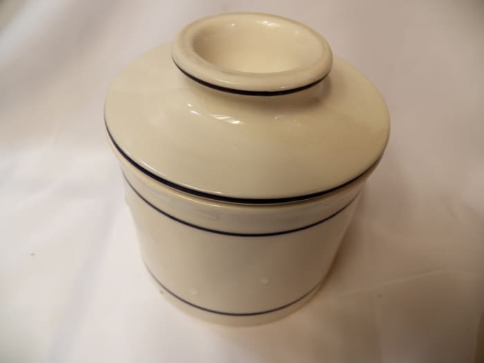 Bell-shaped lid holds butter, while bottom holds water. Putting lid down into water keeps butter fresh and soft at room temperature.