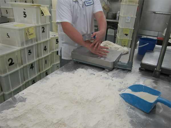 A bench knife is used to cut the dough into portions. 