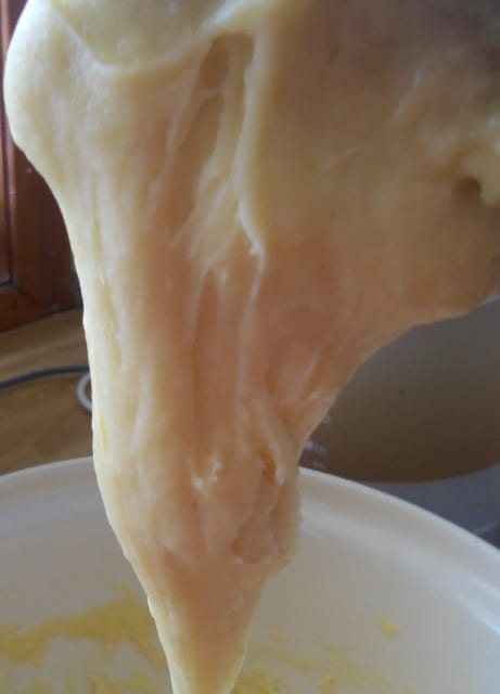 When ready, the dough will be glossy and smooth and will fall from the spoon as shown.