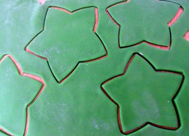 Roll the sugarpaste (fondant) out thinly and cut out the star shapes using the same cutters used for the cookies.
