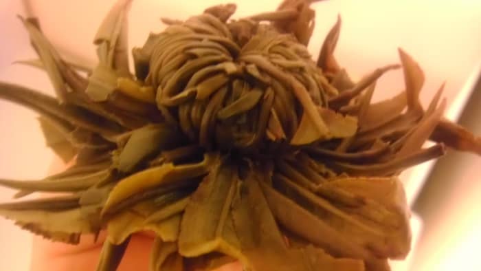 The underside of the flower ball. It is tied together with string and resembles a hat after brewing.
