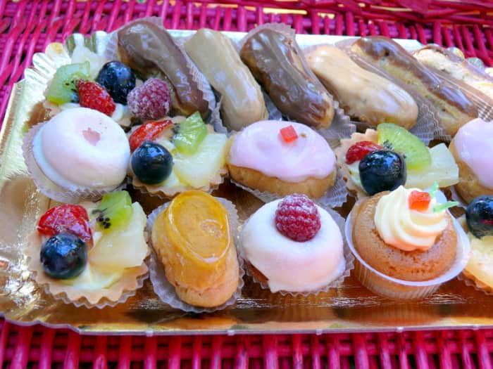 A silver tray of elegant petit fours and miniature tarts, eclairs and puddings
