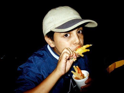 Boy enjoying chicken feet in Mexico City