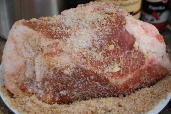 Garlic slices inserted into knife slits, then roast is rolled in the rub all over.