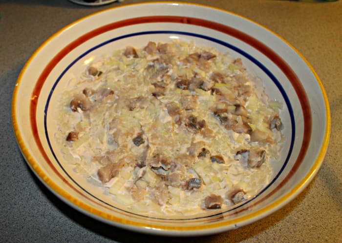 Layer of potatoes on the bottom, then herring, then onions. Every layer is smeared with mayo. Tip: use the herring sparingly! You don't want it to overpower the dish.