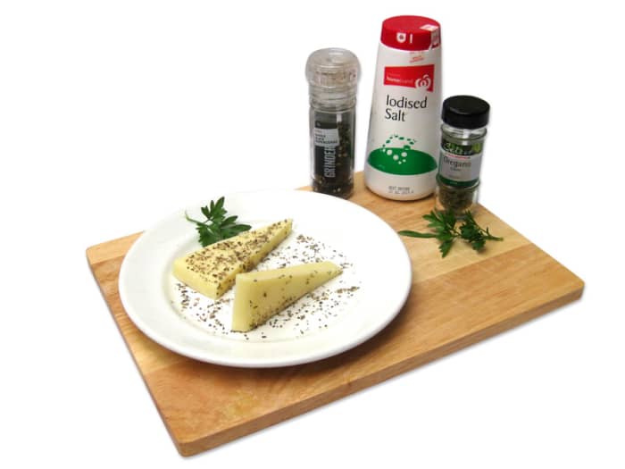 Mix oregano, pepper and salt on a plate and press the cheese into the mix on both sides. You can also use other dried mixed herbs, but oregano is the Greek preference.