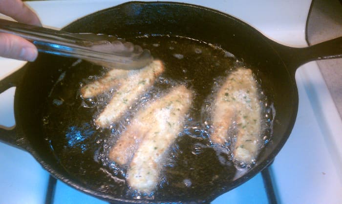 Carefully place breaded fish into hot oil using metal tongs or a metal slotted spoon. Be gentle, as splashing the oil could cause burn or fire!
