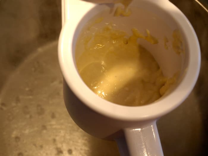 Cook the noodles: Place some of the batter in your spaetzle-maker and add it to the boiling water.