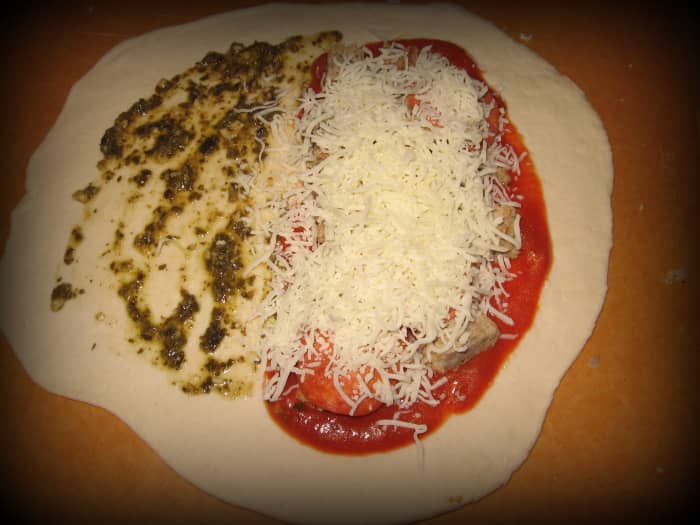Roll your dough into a circle and add toppings, making sure that you leave room around the edges to close the calzone.