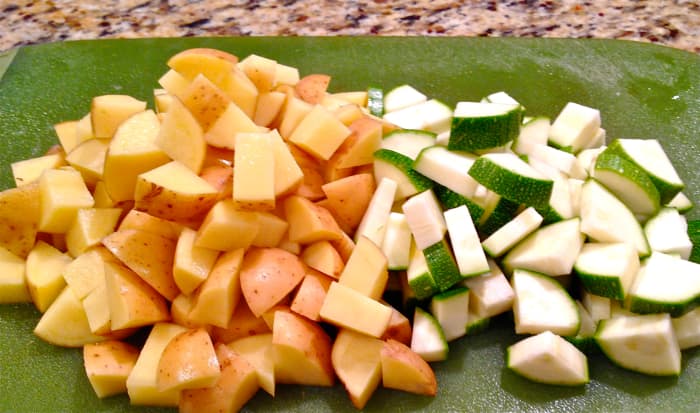 Add broth, water, tomatoes, tomato paste, potatoes, zucchini, parsley, basil, ground pepper, and bay leaf. Bring to a boil then lower heat to simmer, cook until vegetables are soft, about 35-45 minutes.