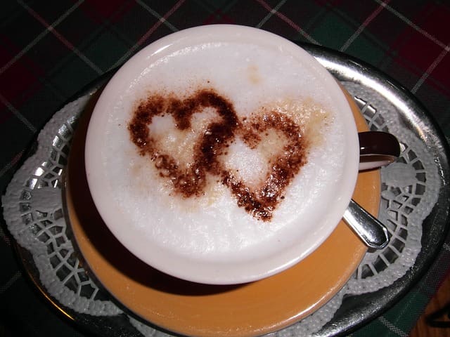 Cappucino coffee drink featuring two love hearts on the foam. A creamy and thick head is essential for cappuccino drinks. Creative people use the foam to make engaging images and patterns for coffee drinkers in cafes and restaurants.
