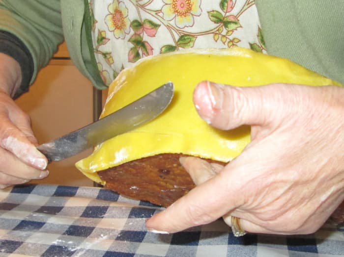 Place the strips of marzipan around the cake and push together so that it is firmly and evenly placed.