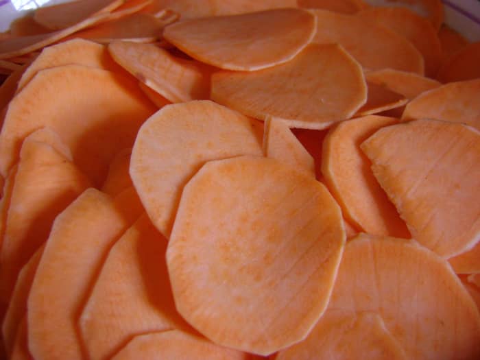 Once the oil is hot and ready to go, I start cooking the sweet potato slices, while they cook, I continue to peel and slice to save time.