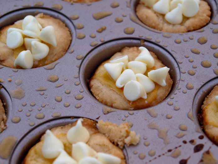 After baking the cookies and while still hot from the oven, run a knife around each cookie and then top each cookie with 8 chocolate chips. Set aside to cool completely before removing from the baking tray.