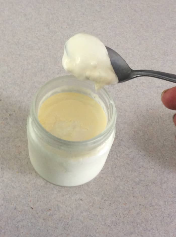5. Stir a scant teaspoonful of yogurt (from the previous batch) into each container of warm milk.