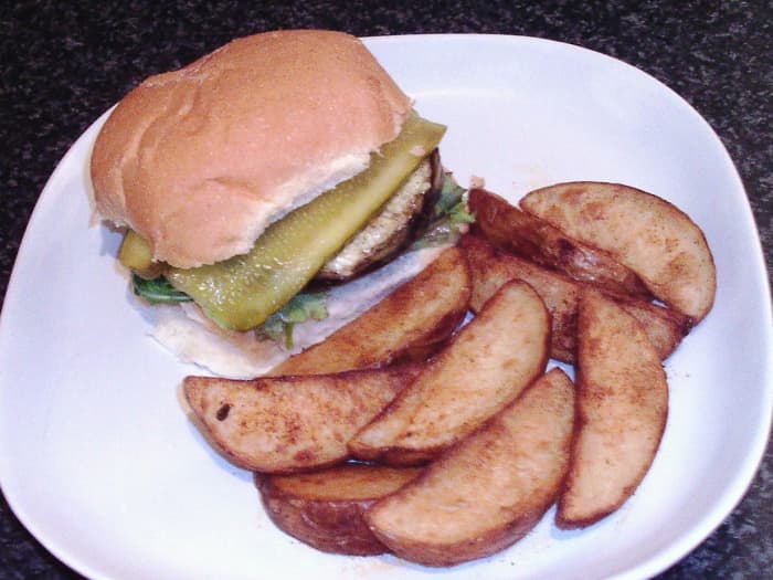 Cheese stuffed mushroom is served as a burger with salad, pickles and spicy deep fried potato wedges