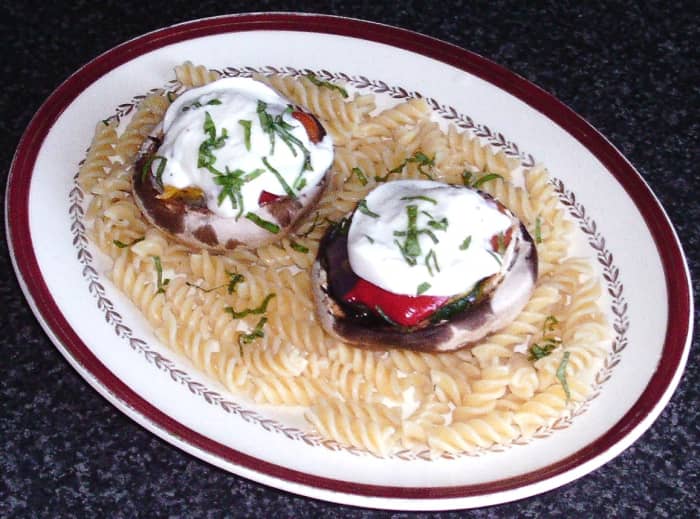 Mushrooms stuffed with mixed roasted vegetables, topped with buffalo mozzarella and served on a bed of pasta