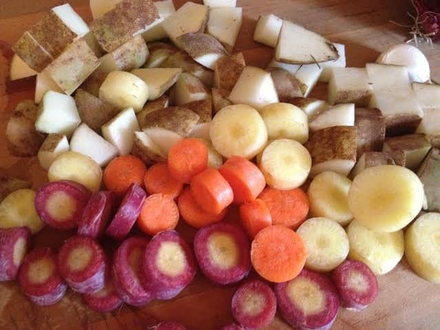 Preheat your oven to 350°F and chop the carrots, potatoes, and onions. Chop the garlic into small pieces.