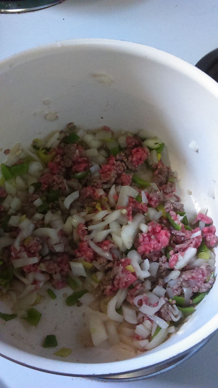 Onion, ground beef, and pepper browning. I only cook half of the ground beef at a time because I have ceramic cookware that I love and don't like over heating. So I find the meat cooks more evenly on medium heat with half a pound at a time.
