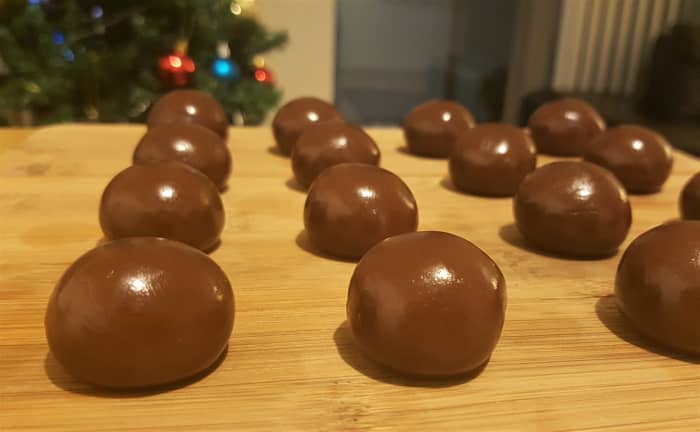 Allow the brigadeiro to cool and stiffen. When ready, the brigadeiro should be easy to hold and malleable like a soft fudge. Roll portions into small spheres with your hands.