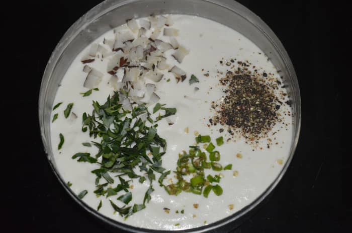Step two: Grind them adding very little water to get a smooth paste. Add chopped curry leaves, pepper powder, chopped green chilies, chopped dry coconut, and salt.