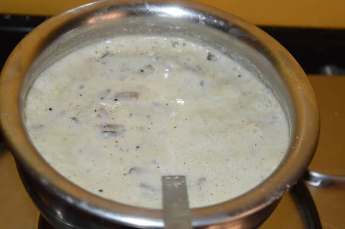 Step 3: Cook chopped taro stems in a deep-bottomed pan or vessel for about 10 minutes. Add salt and tamarind juice. Pour ground coconut masala mix, and curds/yogurt into the vessel. Mix well.