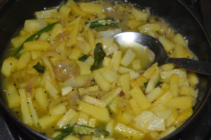 Step 7: Pour in a cup of water. Cover the pan. Cook till potato becomes soft, but not mushy. Add chopped coriander leaves and lemon juice. Mix well.