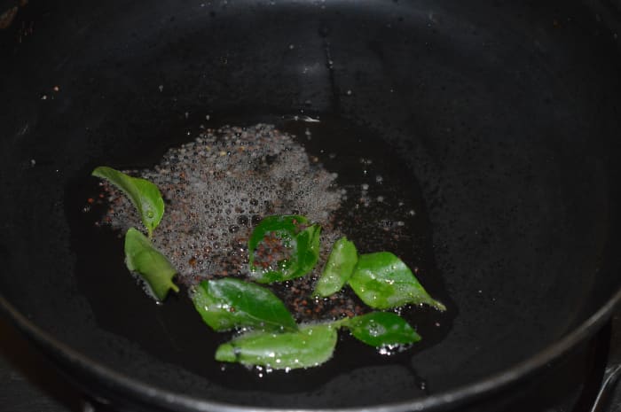 Step 3: Heat oil in a deep-bottomed pan. Add mustard seeds and curry leaves. Let the mustard crackle.