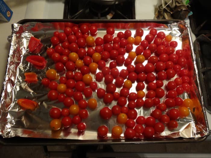 Place jalapeno pepper halves and cherry tomatoes in a single layer on an aluminum foil lined baking sheet.