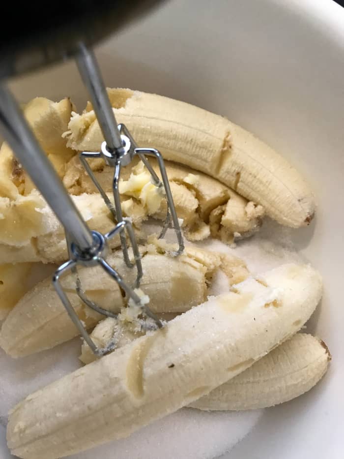 Go ahead and throw the bananas in when you're creaming together the butter and sugar. I find that you get a beautiful texture and consistency in the finished bread when you do this. The banana is mashed up and incorporated much better this way.