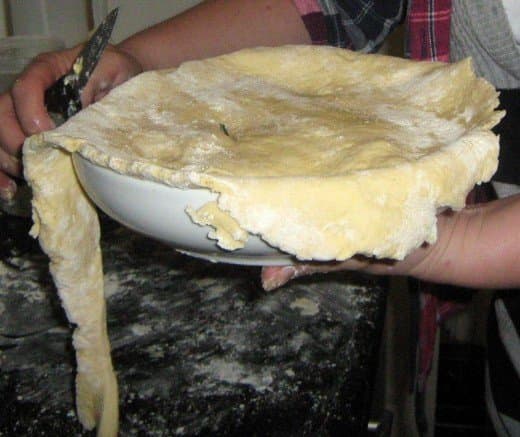 Place the pastry on top of the apples and press down. Using your thumbs, squeeze the pastry securely around the edges.