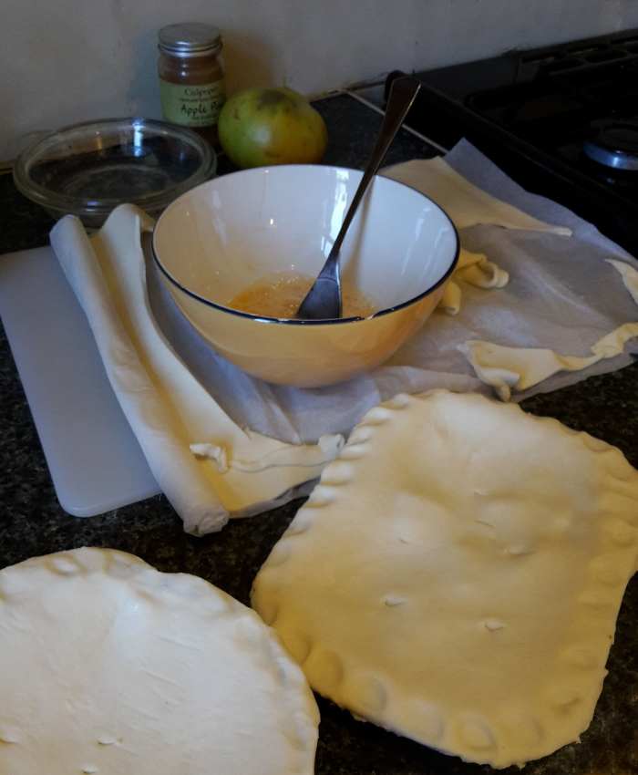 This pastry has been cut and then laid and pressed onto pie dishes, ready to be smeared with whipped egg.