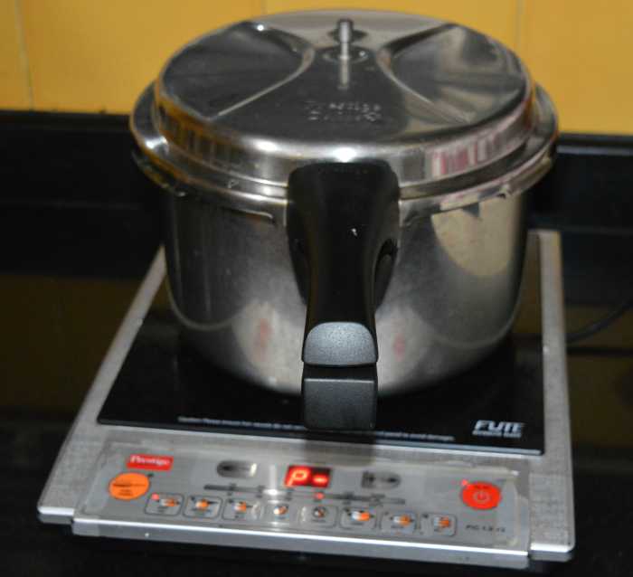 The cooker with the idli stand inside. Set the heat on medium-high. Steam-cook up to 10 or 11 minutes. Next, turn off the heat. Open the lid after 2 to 3 minutes.