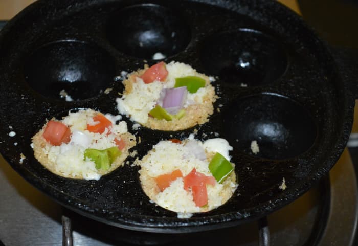 Step six: Add grated mozzarella cheese. Add Italian seasonings and salt-pepper powder on the top. Cover the pan. Keep the pan on medium heat.