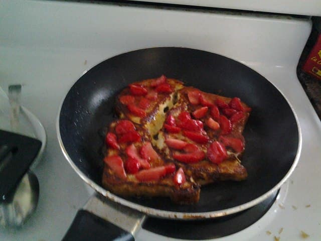 I used frozen strawberries and in order to defrost and heat them without burning them, I cut them up into somewhat small pieces, then laid them on the surface of the bread slices after I had flipped them. This way I got hot juicy berries on my grenki