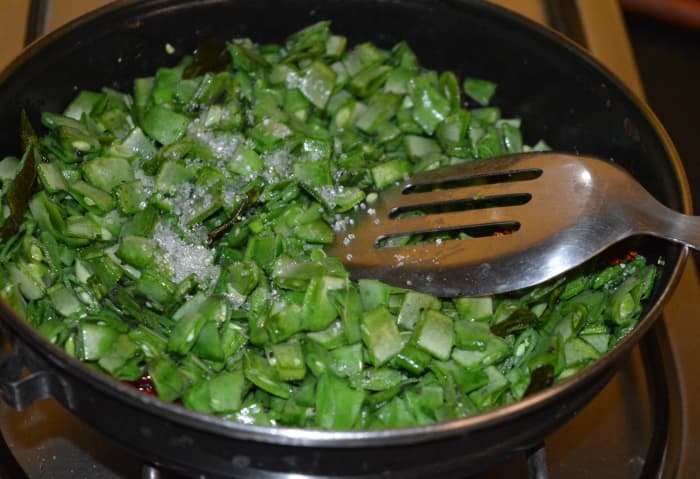 Step four: Add sugar or jaggery powder and two cups of water. Mix well. Cover the pan. Cook while stirring occasionally.