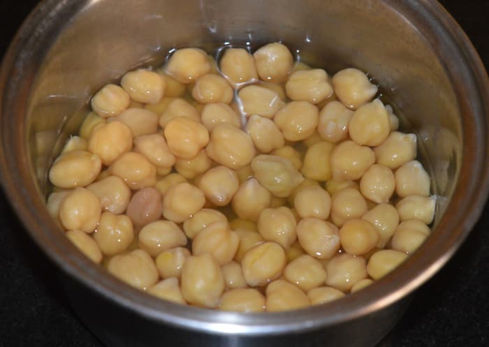 Step one: Soak chickpeas (garbanzo beans) overnight. Cook them with a little salt and water. If cooking in a pressure cooker, cook until 4 whistles and simmer for 10 minutes.