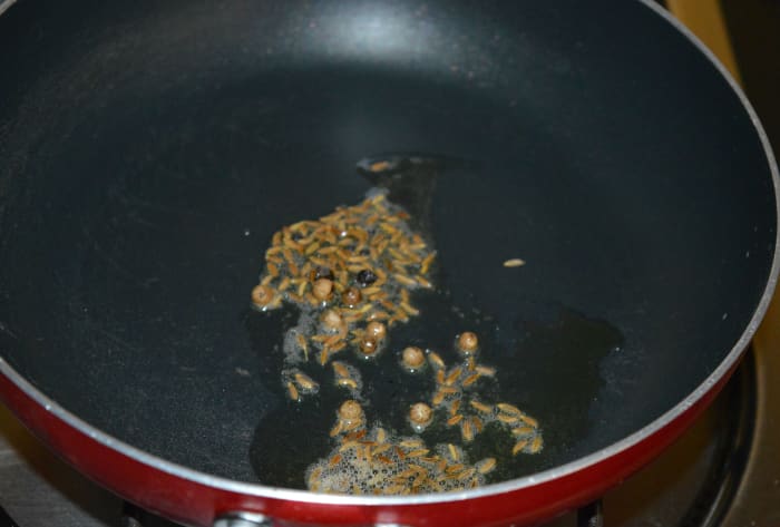 Step 1: Heat 1/2 teaspoon of ghee in a deep-bottomed pan. Throw in cumin seeds and peppercorns. Let cumin sizzle.