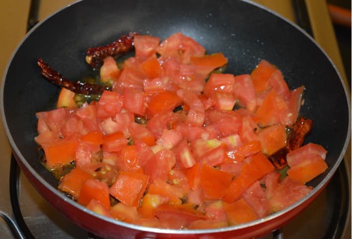 Step two: Add tomatoes. Throw in some salt. Stir-cook over medium high heat until tomatoes become mushy.