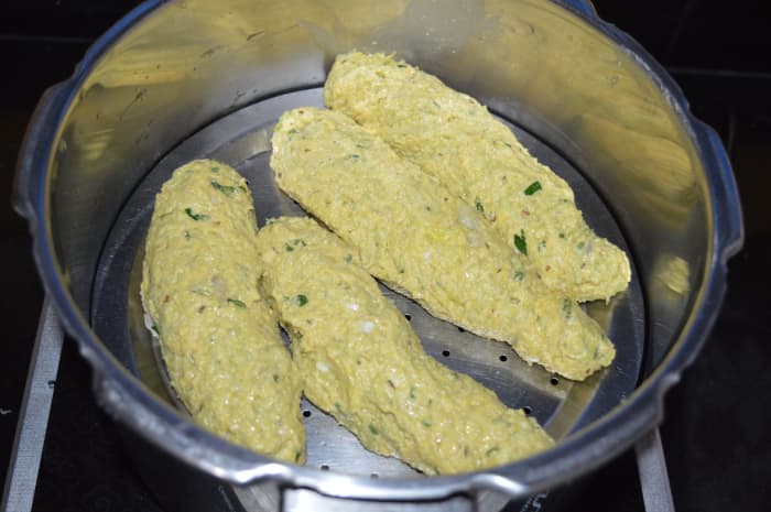 Step three: Knead together to make a firm, smooth dough. If needed, use bottle gourd water for kneading the dough. Divide the dough in four equal portions. Shape each of them like a cylindrical roll.