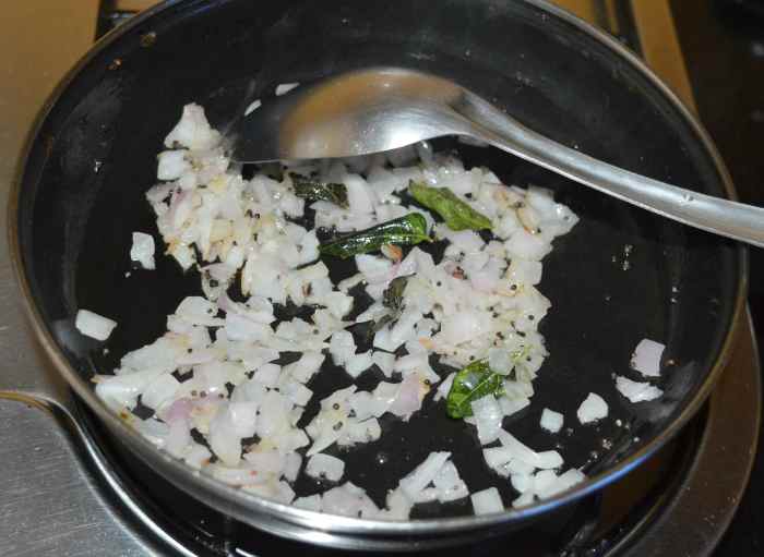 Step three: Heat oil in a deep-bottomed pan. Throw in mustard seeds. Let them crackle. Add chopped onions. Saute until onions are transparent. Add curry leaves and hing powder.