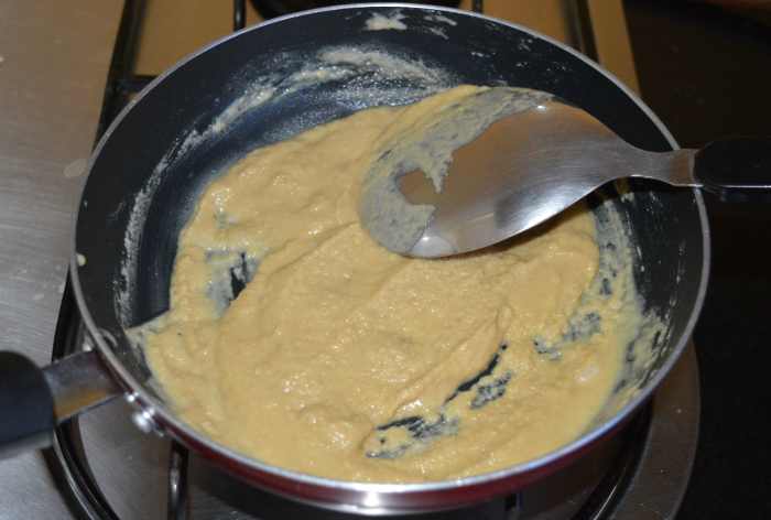 At the start of sauteing, the mixture will be like a liquid. Then it becomes thicker and lighter. In the final stage, it changes color, becomes a bit porous, and very light compared to earlier. Ghee starts oozing out on the edges