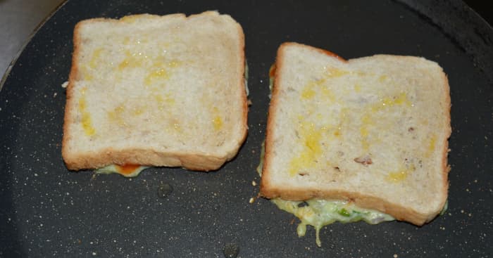 Step five: Heat a pan. Add a few drops of oil or ghee on it. Put the slices upside-down on the pan. Add a few drops of oil or ghee on the top. Toast them on both sides. Turn off the heat.