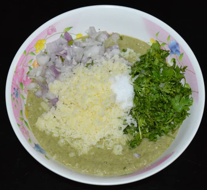 Step two: Put the batter in a mixing bowl. Add grated cheese, chopped coriander, chopped onions, and salt. Mix well.